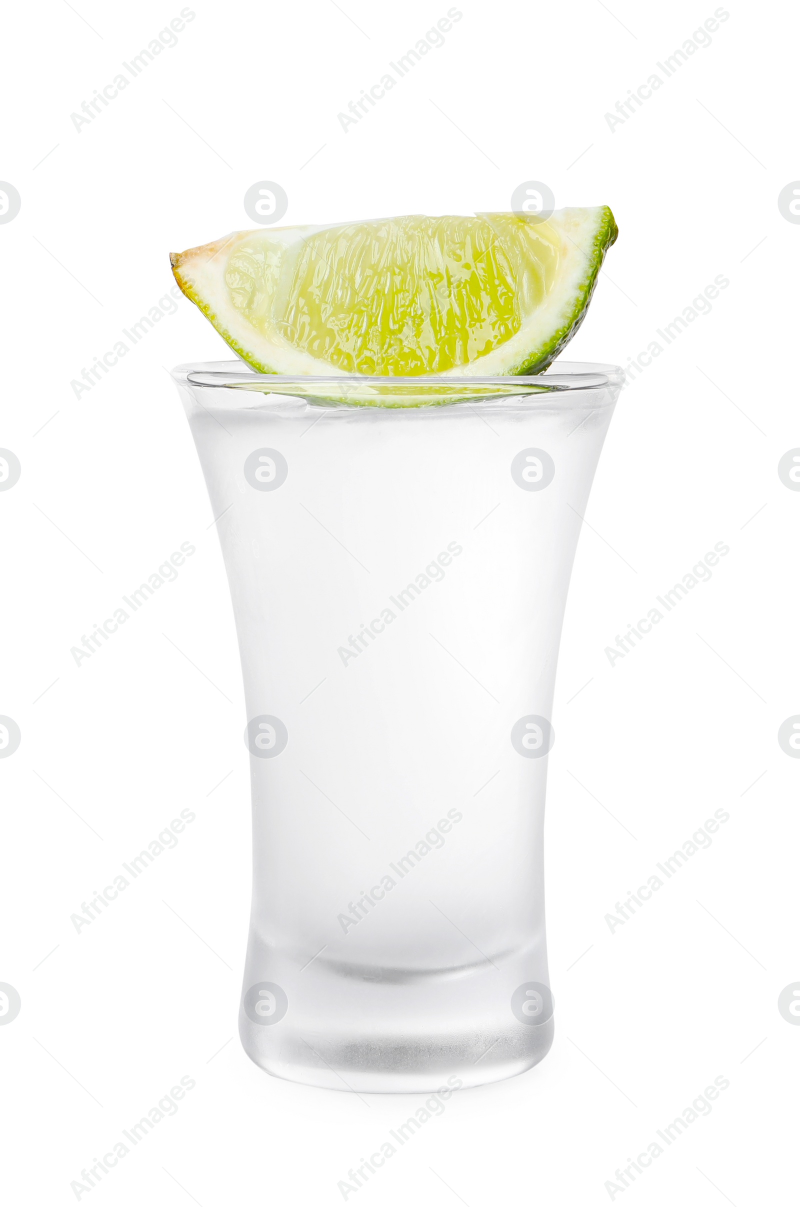 Photo of Shot glass of vodka and lime isolated on white