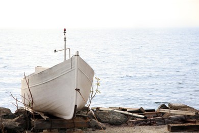 Moored boat on beach near sea outdoors