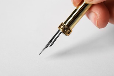 Photo of Woman with fountain pen above white paper, closeup