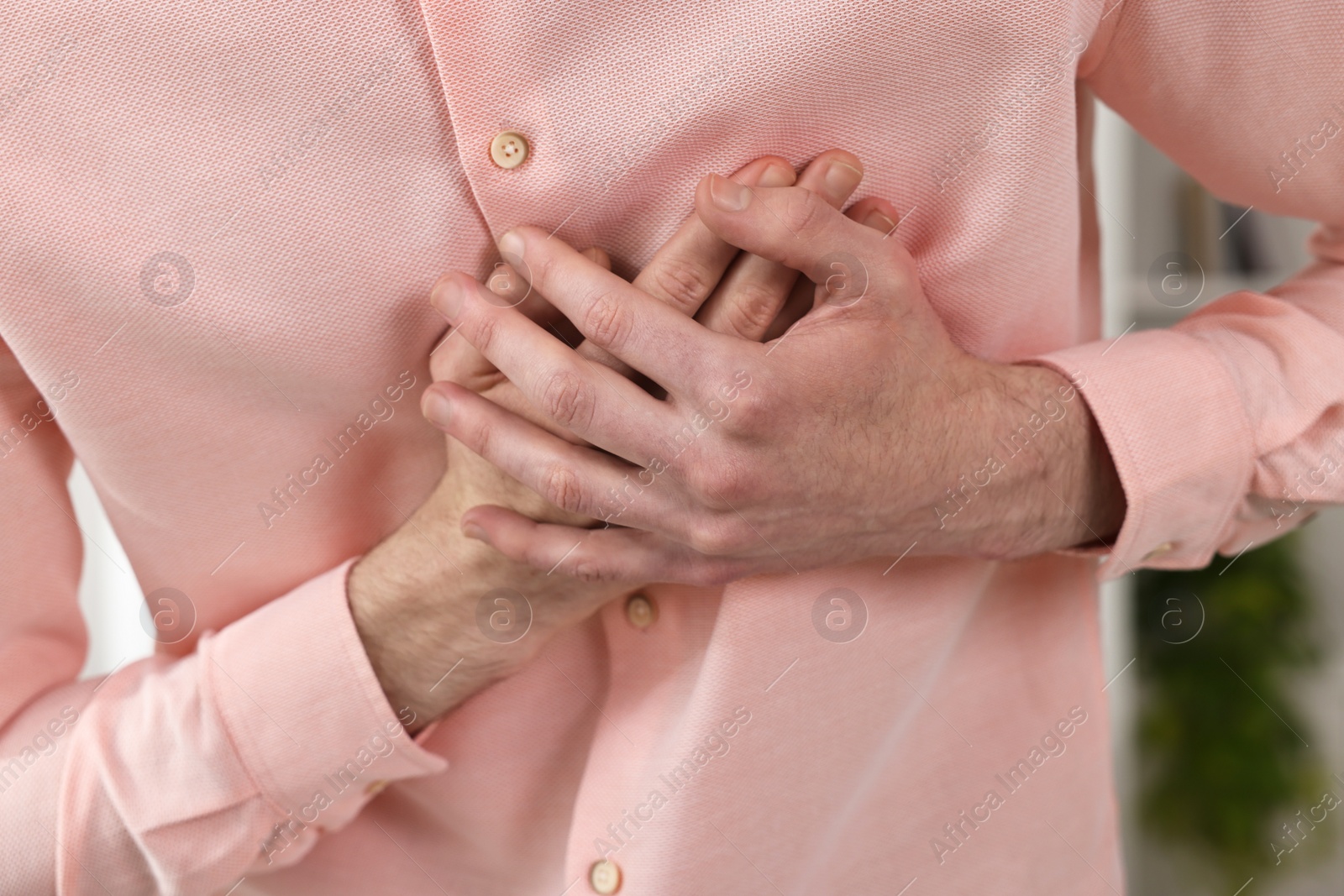 Photo of Man suffering from heart hurt at home, closeup