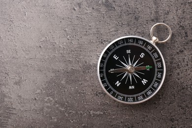 Photo of One compass on grey table, top view. Space for text