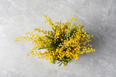 Bouquet of beautiful mimosa flowers on grey table