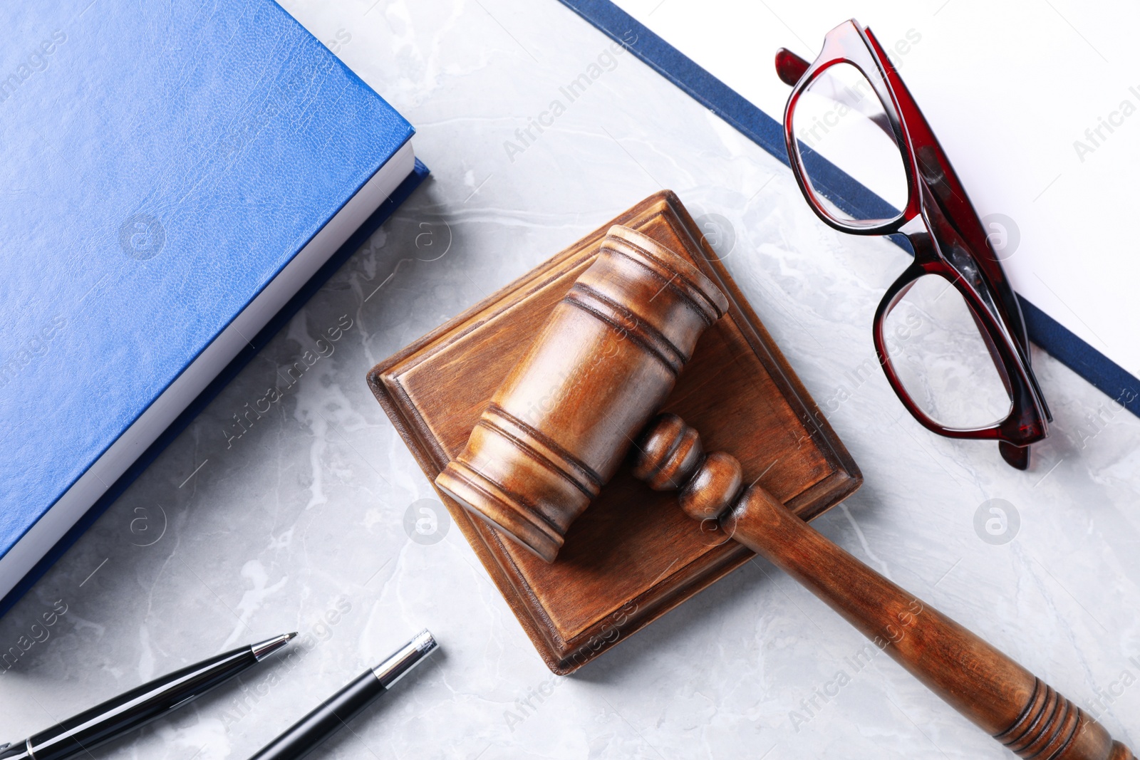 Photo of Flat lay composition with law book and gavel on light grey marble table. Protection from domestic violence