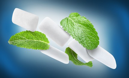 Image of Fresh mint leaves and chewing gum pads falling on blue background