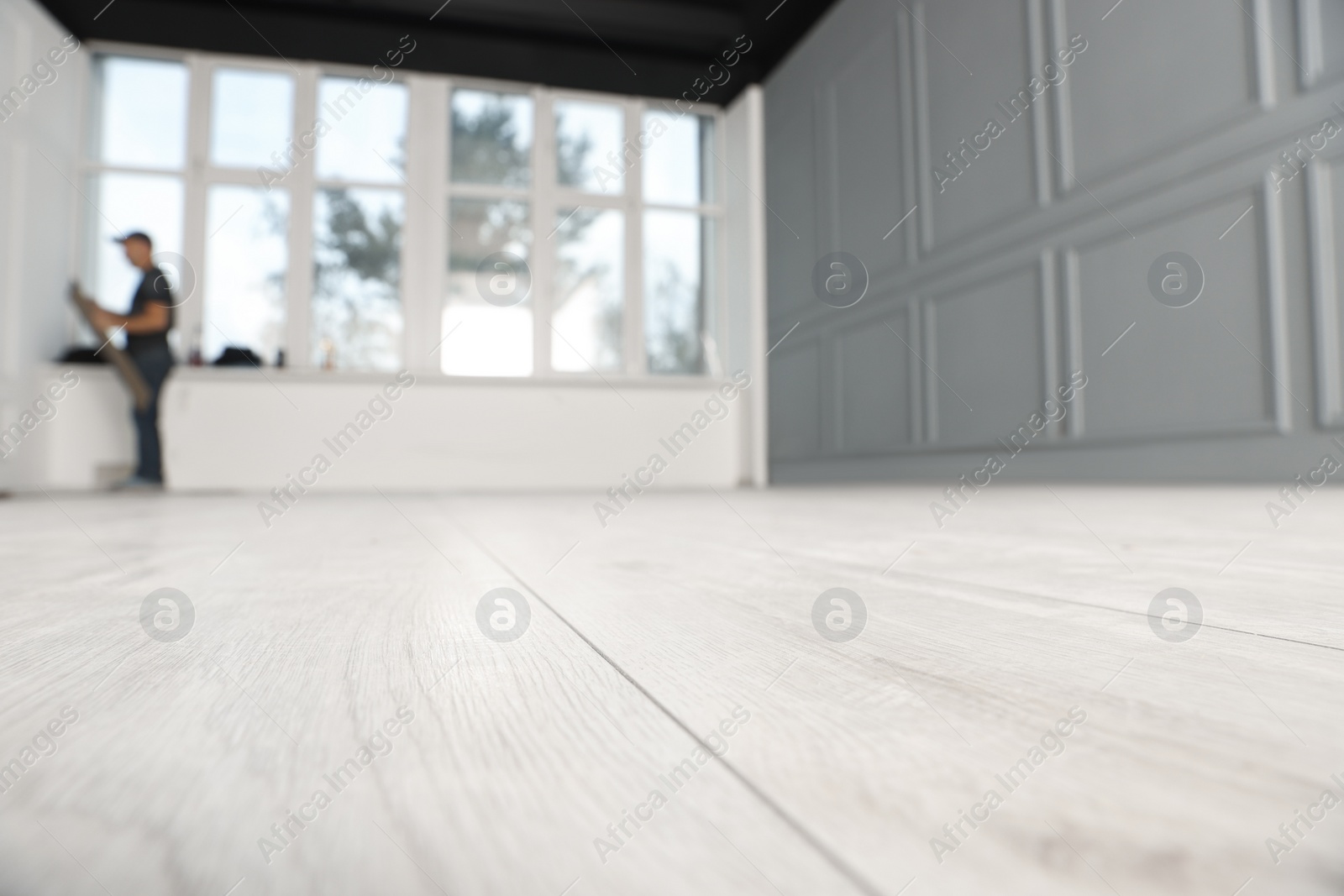 Photo of Empty room with new white laminated flooring, closeup