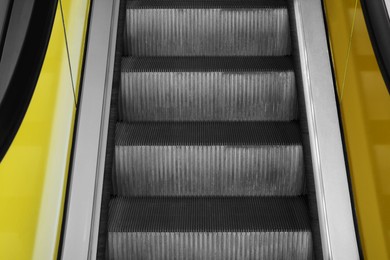 Photo of View on empty escalator with yellow balustrades, closeup