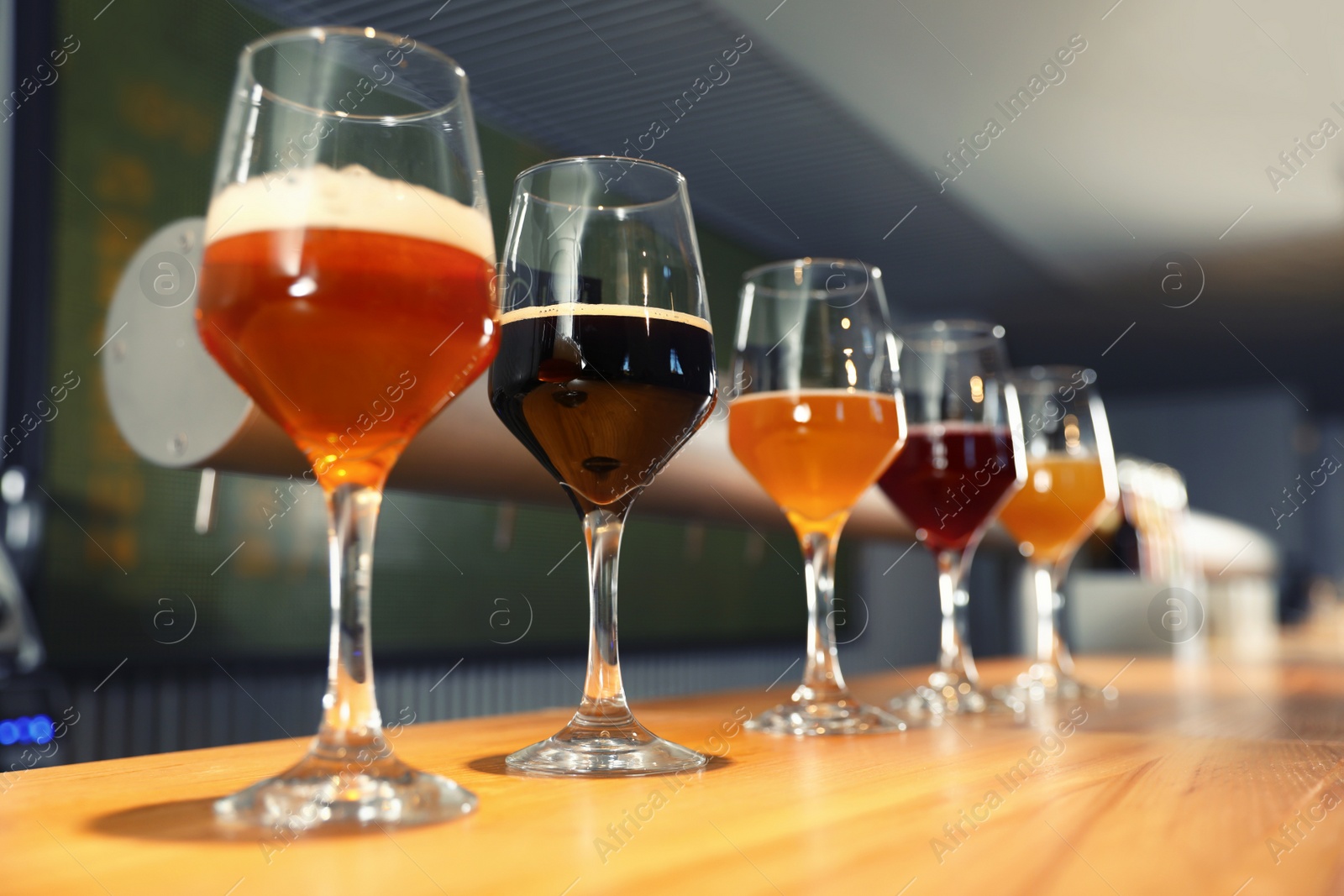 Photo of Different sorts of beer on wooden bar counter