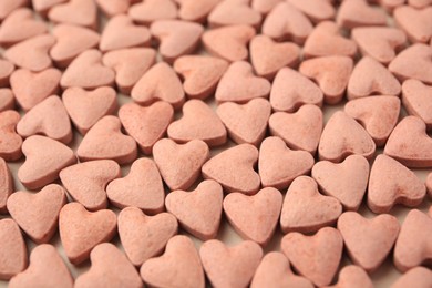 Photo of Heart shaped vitamins for pets as background, closeup