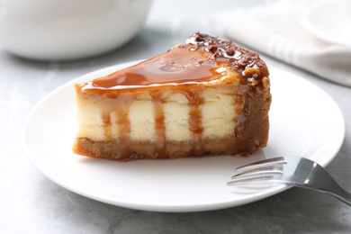 Piece of delicious cake with caramel served on marble table