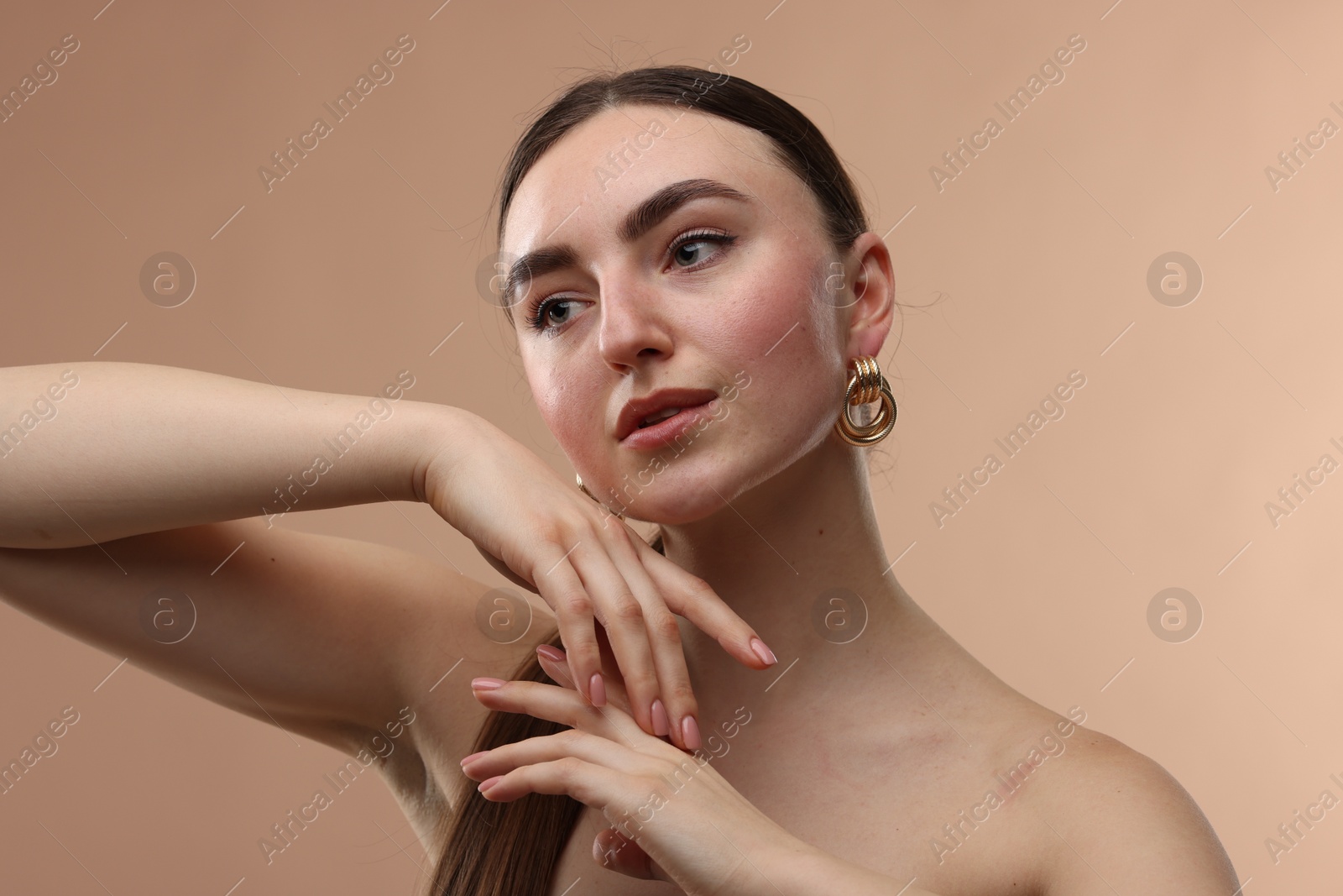 Photo of Portrait of beautiful young woman on beige background