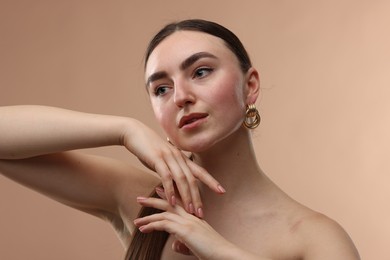 Portrait of beautiful young woman on beige background