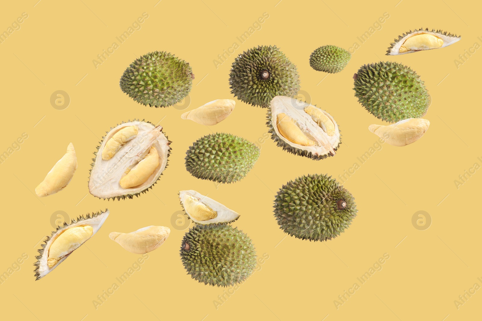 Image of Fresh ripe durians falling on pale yellow background