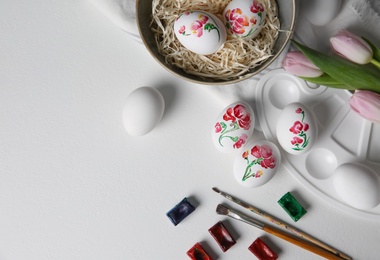 Photo of Painting Easter eggs on white table, flat lay. Space for text
