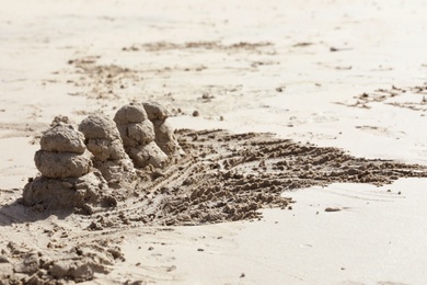 Photo of Seashore with sand sculptures on sunny day. Space for text
