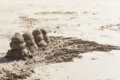 Seashore with sand sculptures on sunny day. Space for text