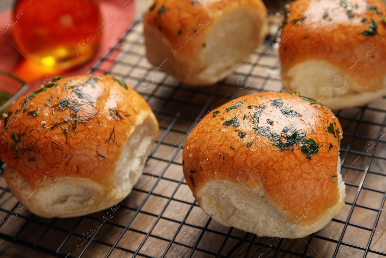 Photo of Traditional Ukrainian bread (Pampushky) with garlic on baking grid, closeup