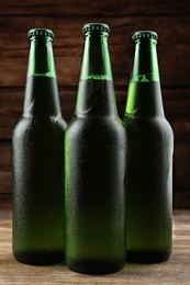 Photo of Many bottles of beer on wooden table, closeup