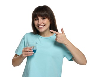 Photo of Young woman with mouthwash pointing at her healthy teeth on white background