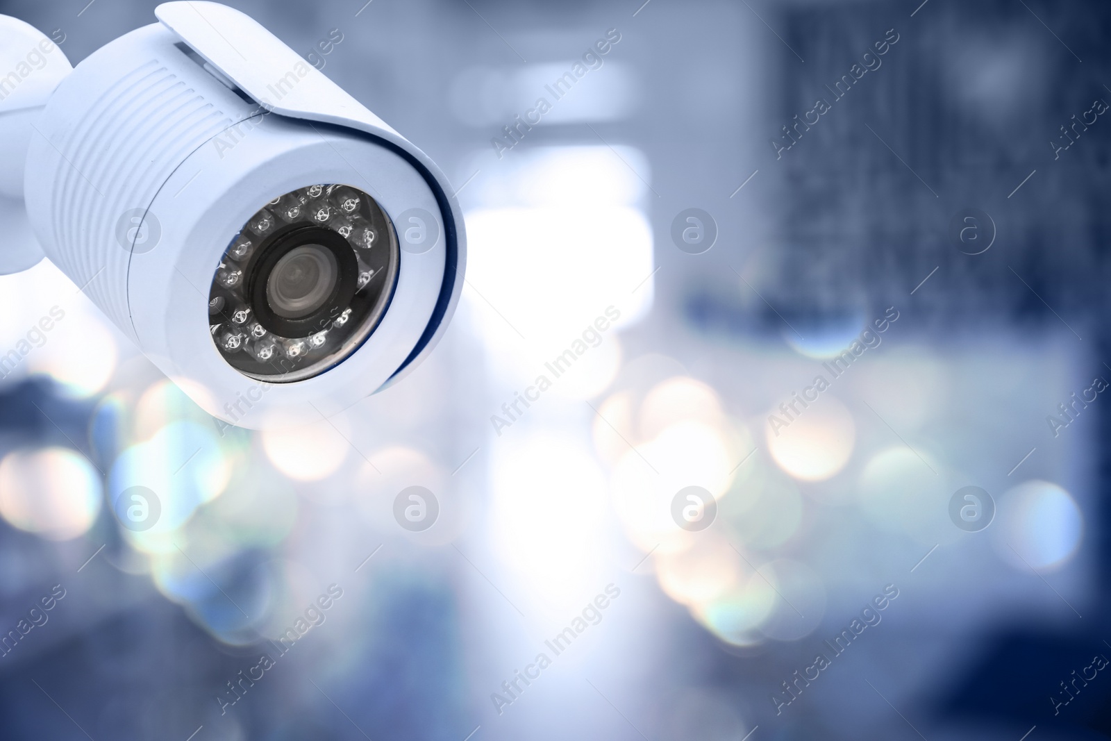 Image of Modern security CCTV camera against blurred background, space for text