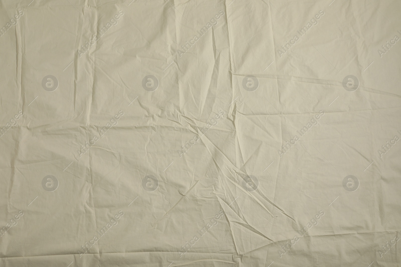 Photo of Crumpled beige fabric as background, top view