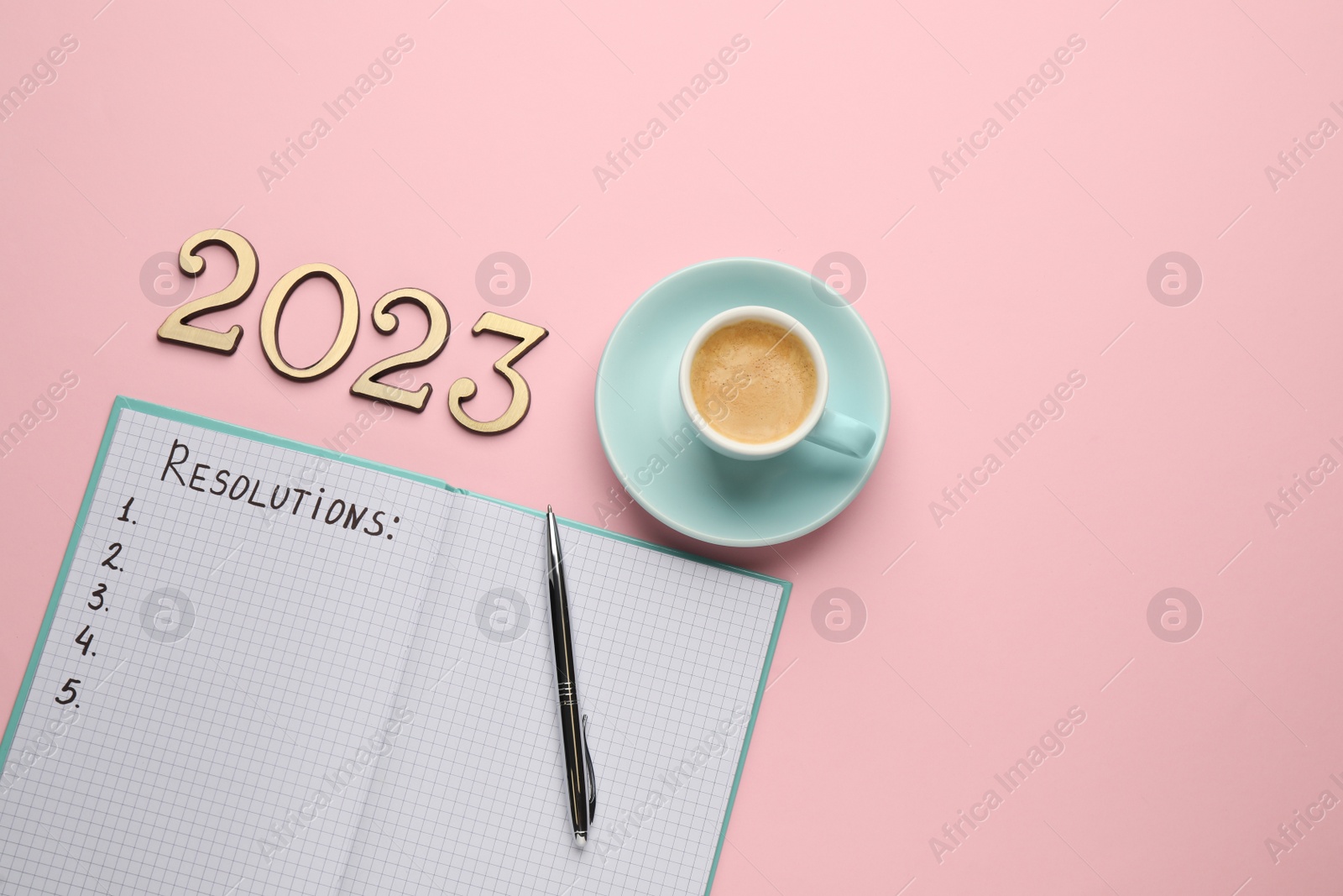 Photo of Making resolutions for 2023 New Year. Flat lay composition with notebook on pink background