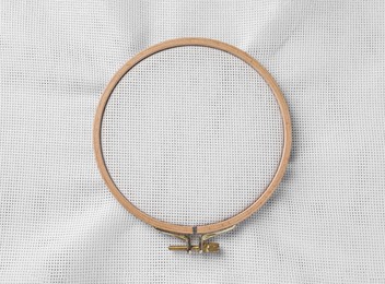 Photo of Embroidery hoop with white fabric stretched as background, top view