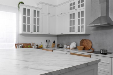 Photo of Stylish white marble table in kitchen. Interior design