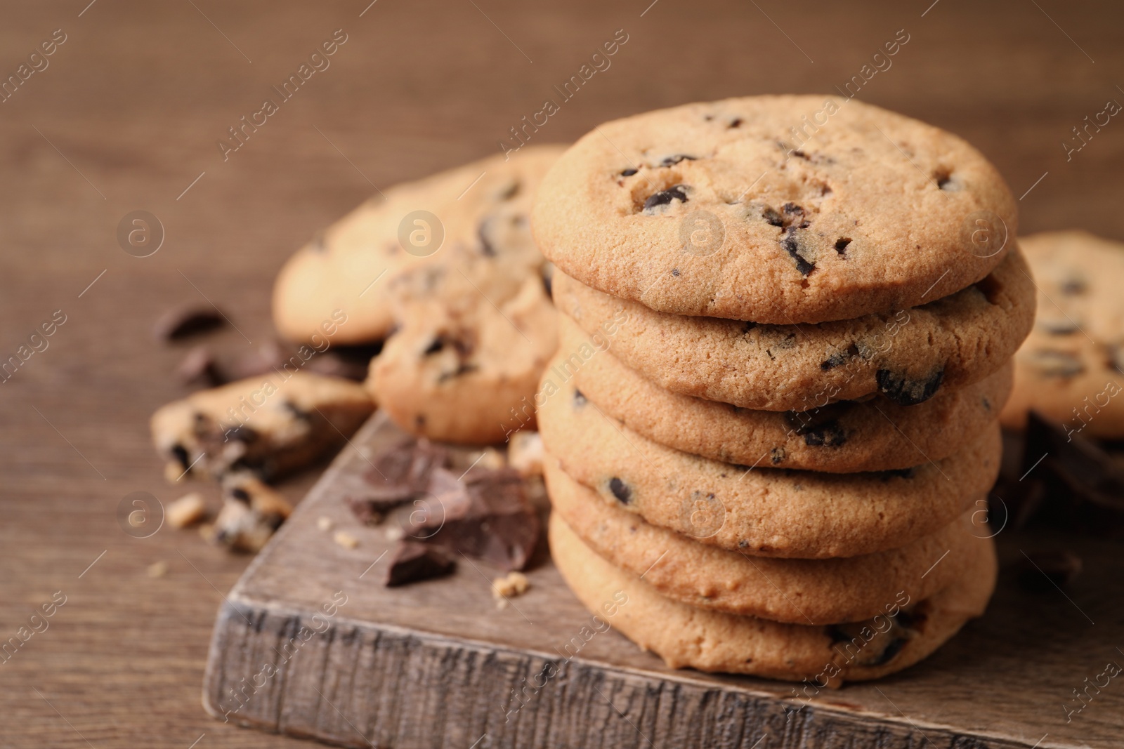 Photo of Delicious chocolate chip cookies on wooden table, closeup. Space for text