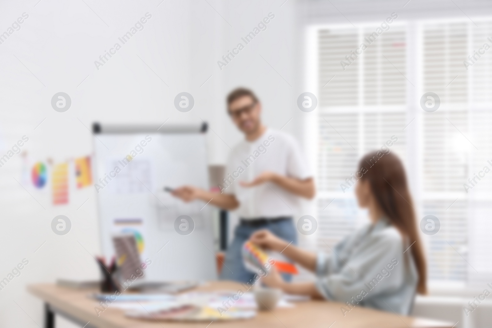 Image of Blurred view of professional interior designers working in office