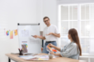 Image of Blurred view of professional interior designers working in office