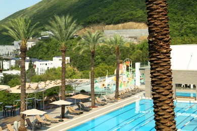 Photo of Outdoor swimming pool at luxury resort and beautiful view of mountains on sunny day
