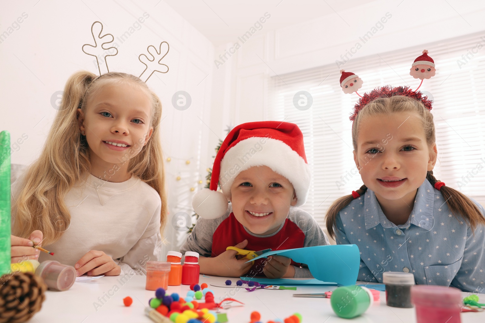 Photo of Cute little children making Christmas crafts at table in room