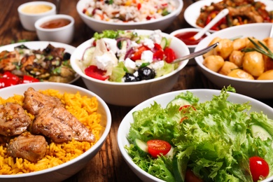 Photo of Buffet service. Many different dishes on wooden table