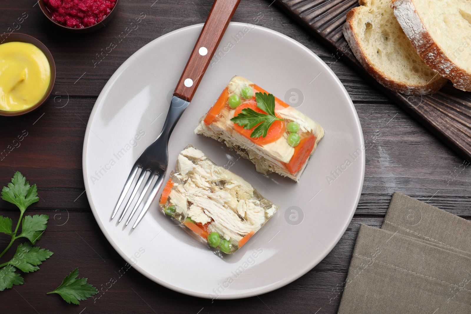 Photo of Delicious chicken aspic served on wooden table, flat lay