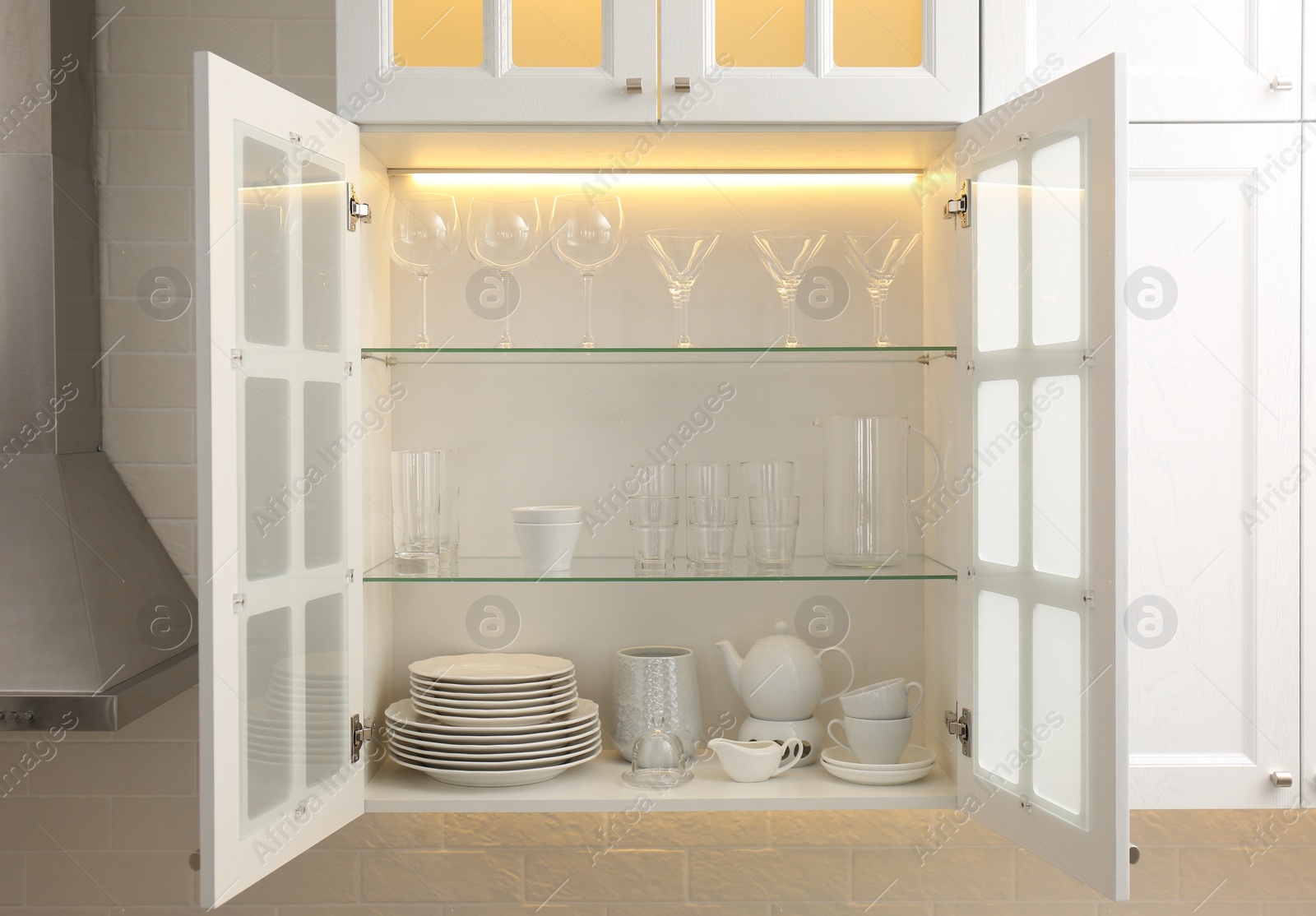 Photo of Cabinet with crockery and glassware. Order in kitchen