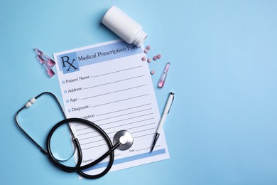 Photo of Medical prescription form, stethoscope, ampoules and pills on light blue background. Space for text