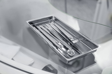 Photo of Professional dentist tools on glass table in clinic