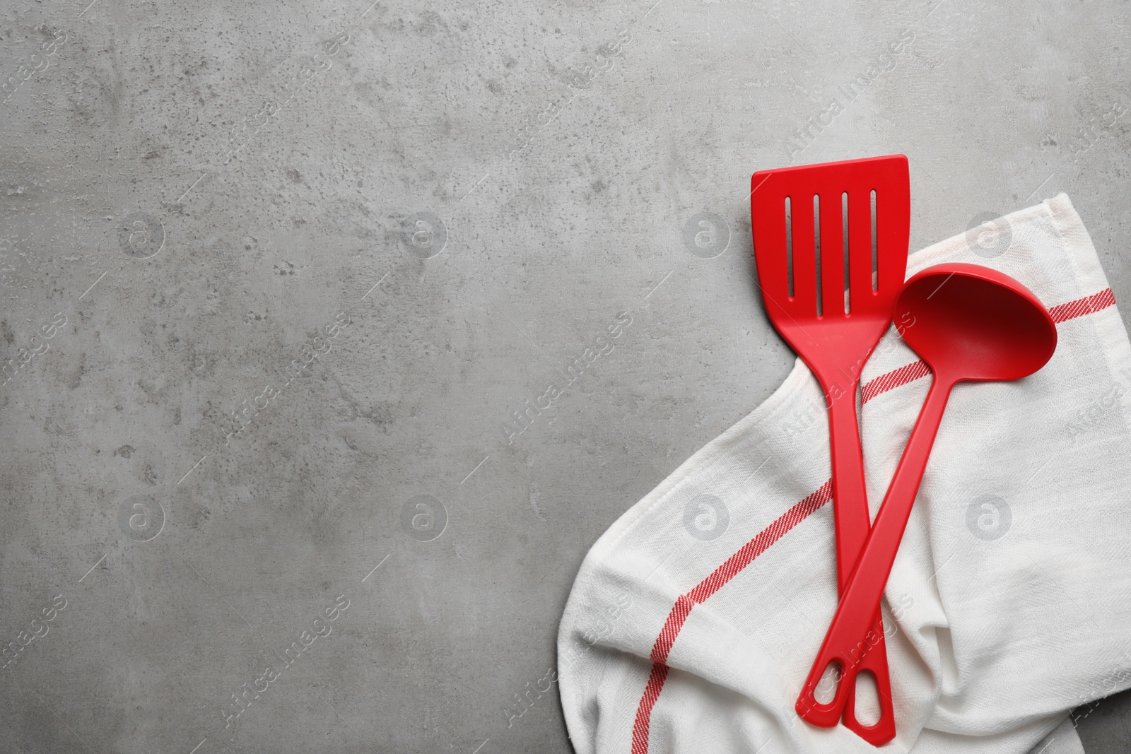 Photo of Kitchen utensils and napkin on grey background, top view with space for text