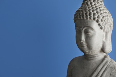 Photo of Beautiful stone Buddha sculpture on blue background. Space for text