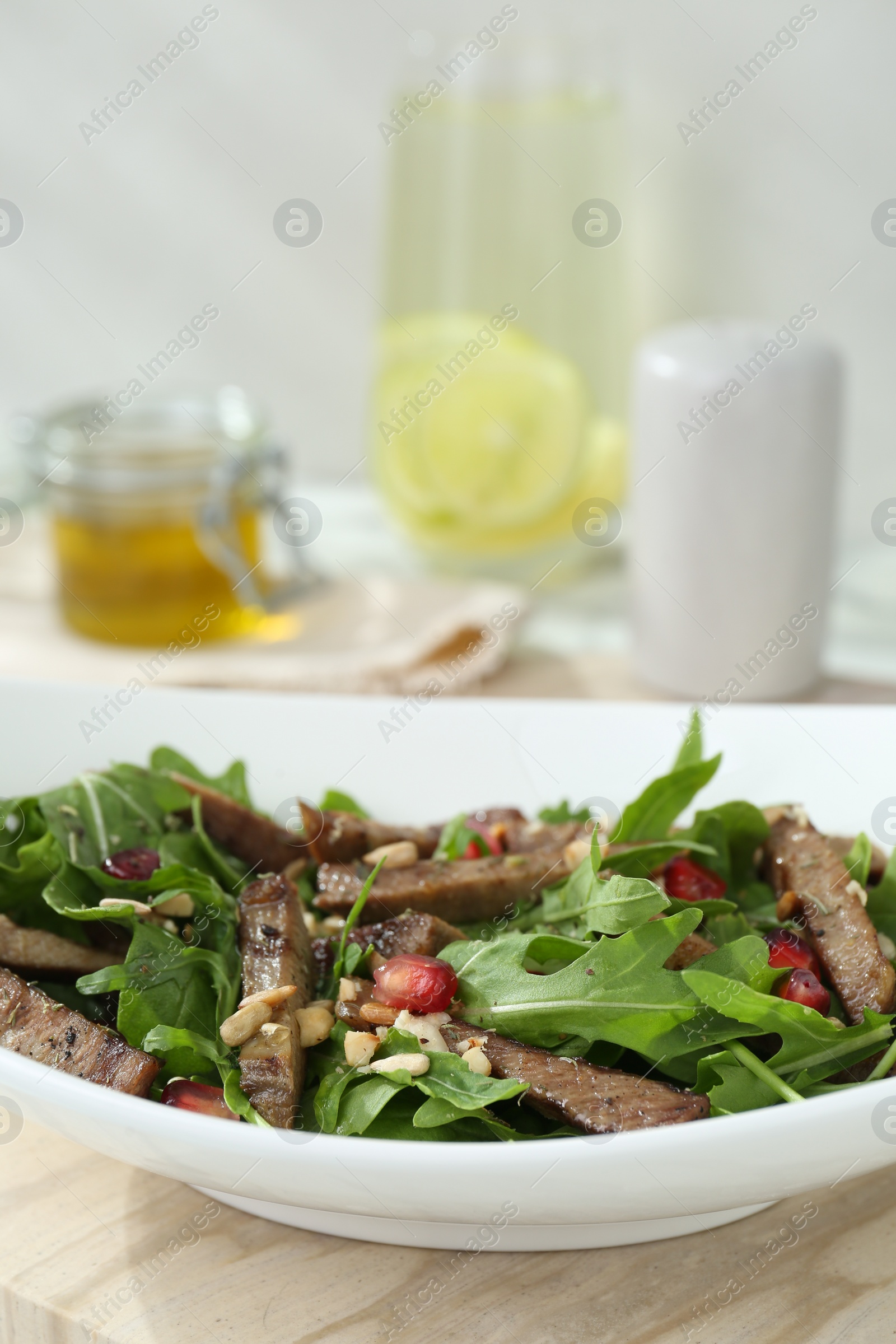 Photo of Delicious salad with beef tongue, arugula and seeds on table