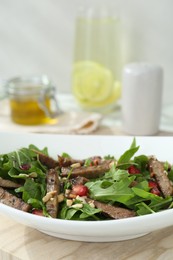 Delicious salad with beef tongue, arugula and seeds on table