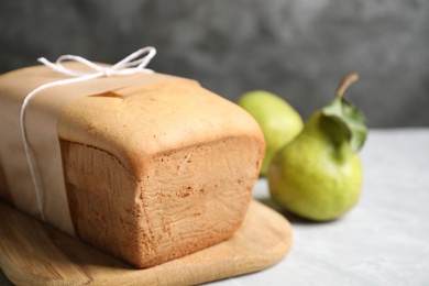 Photo of Tasty tied pear bread on light table, closeup. Homemade cake