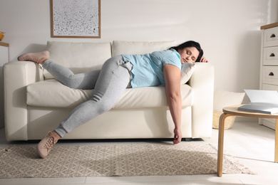 Photo of Lazy overweight woman resting on sofa at home