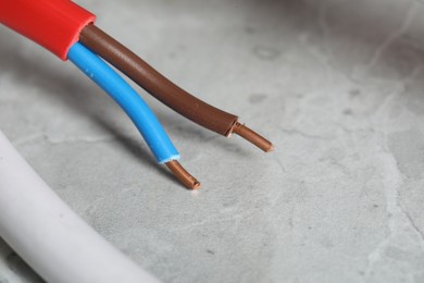 Photo of Colorful electrical wire on gray textured surface, closeup