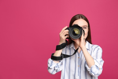 Photo of Professional photographer taking picture on pink background