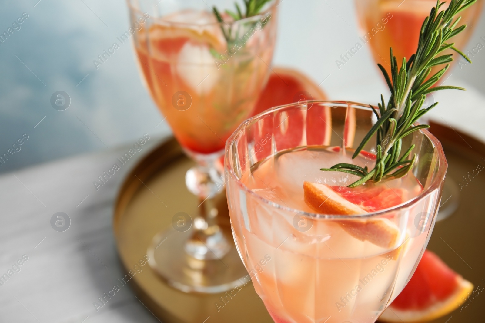 Photo of Glass of grapefruit cocktail on table, closeup. Space for text