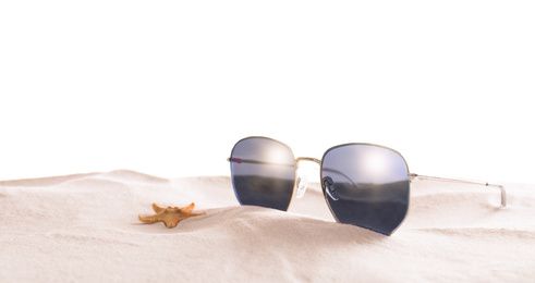 Stylish sunglasses and starfish on sand against white background