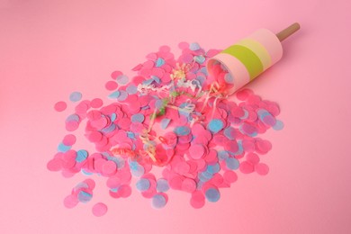 Photo of Colorful confetti, serpentine and party popper on pink background