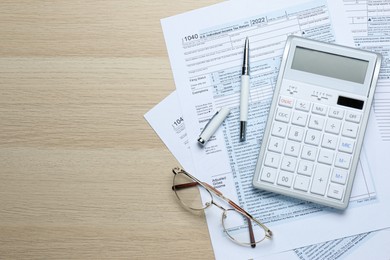 Photo of Calculator, documents, pen and glasses on wooden table, flat lay with space for text. Tax accounting