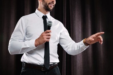 Photo of Motivational speaker with microphone performing on stage, closeup